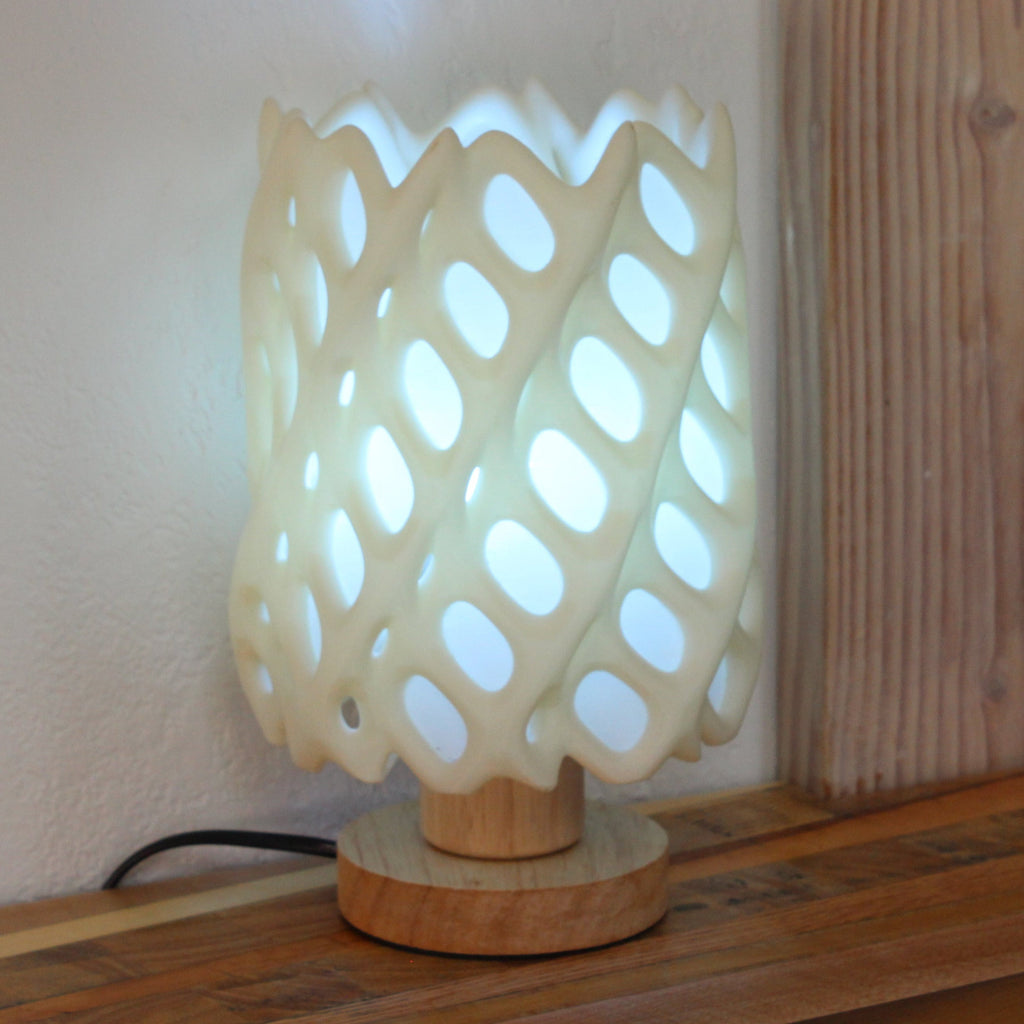 Decorative lamp with a lattice design on a wooden surface.