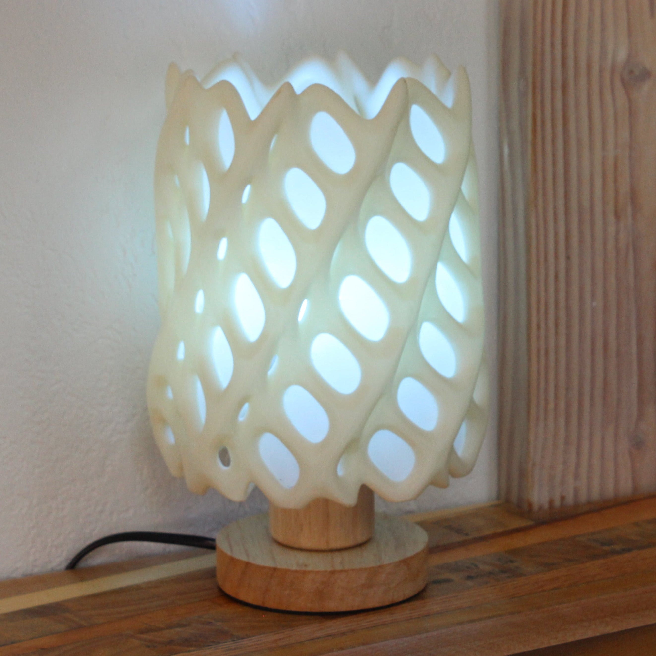 Decorative lamp with a lattice design on a wooden surface.